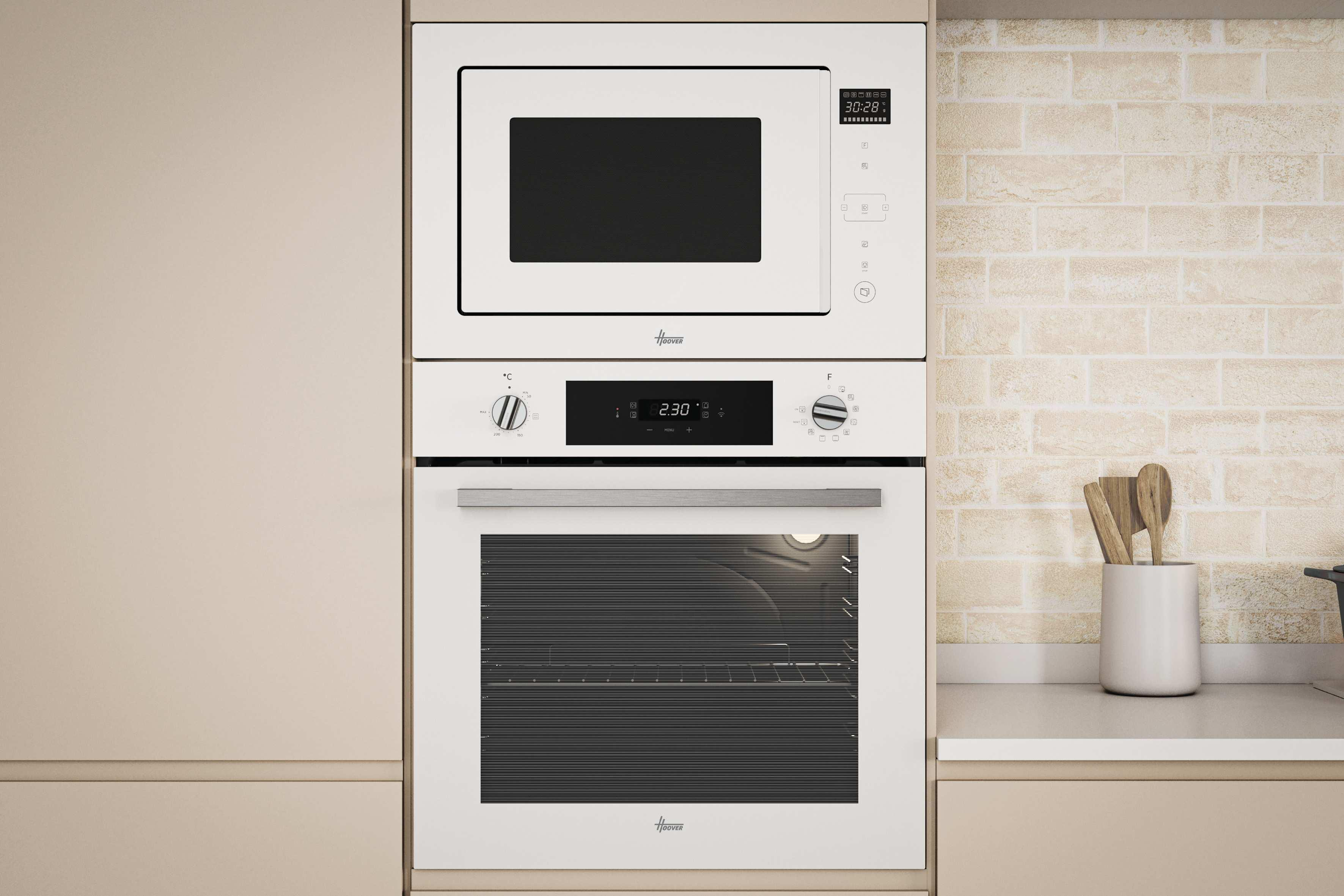 Biała kuchenka mikrofalowa znajduje się nad białym piekarnikiem. Jasna ceglana ściana jest w tle.