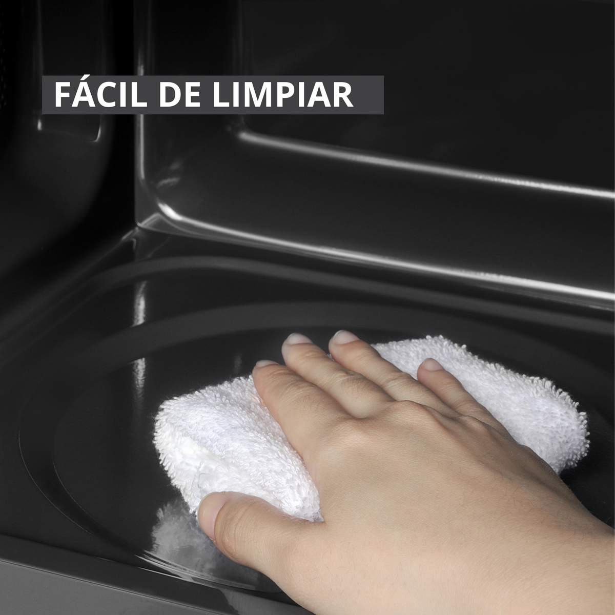 Una mano limpia una superficie interior oscura con un paño blanco. Arriba dice 'Fácil de limpiar'.