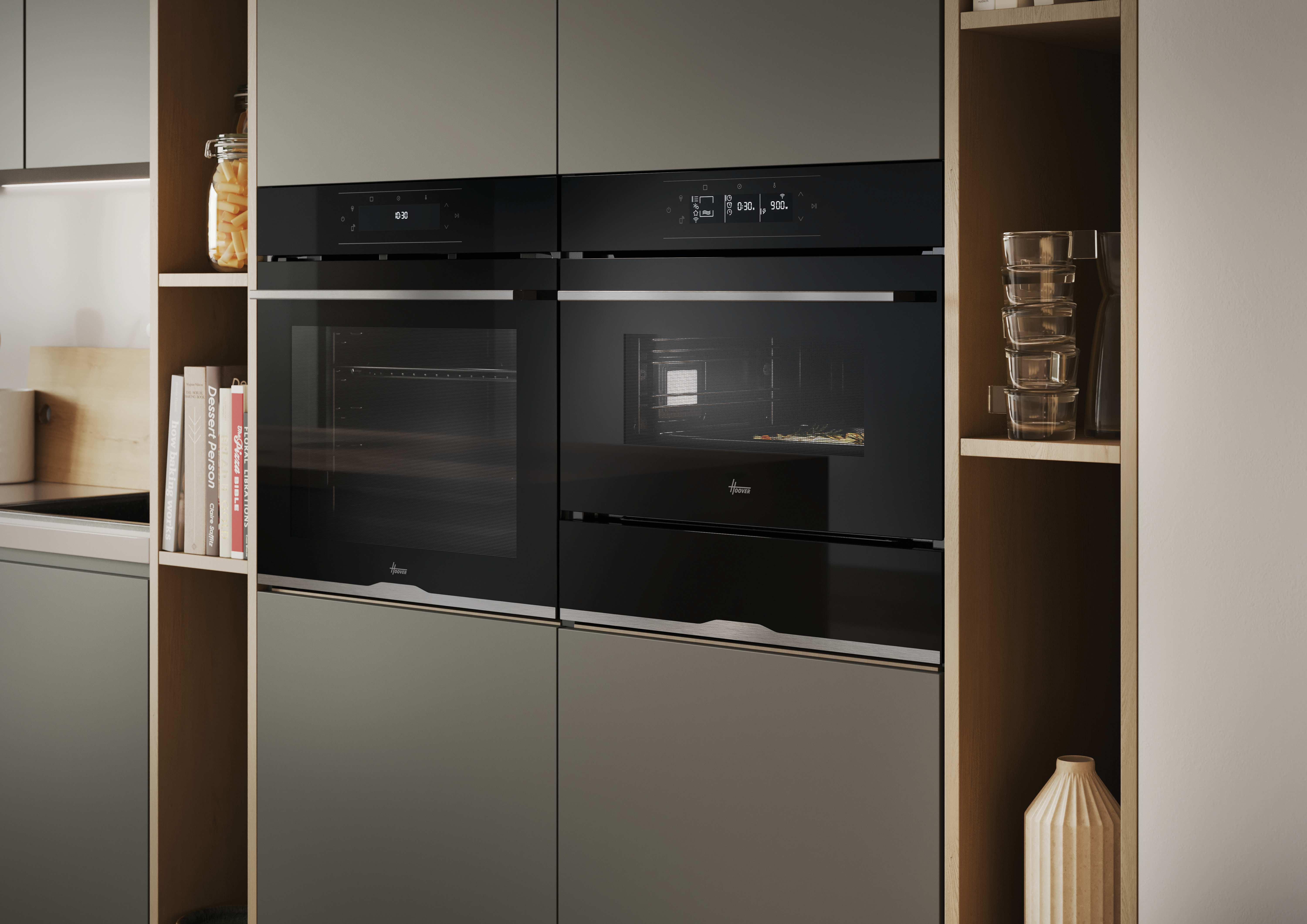 Una cucina moderna con due forni neri, mensole con barattoli, libri e un vaso, tutti in tonalità neutre.