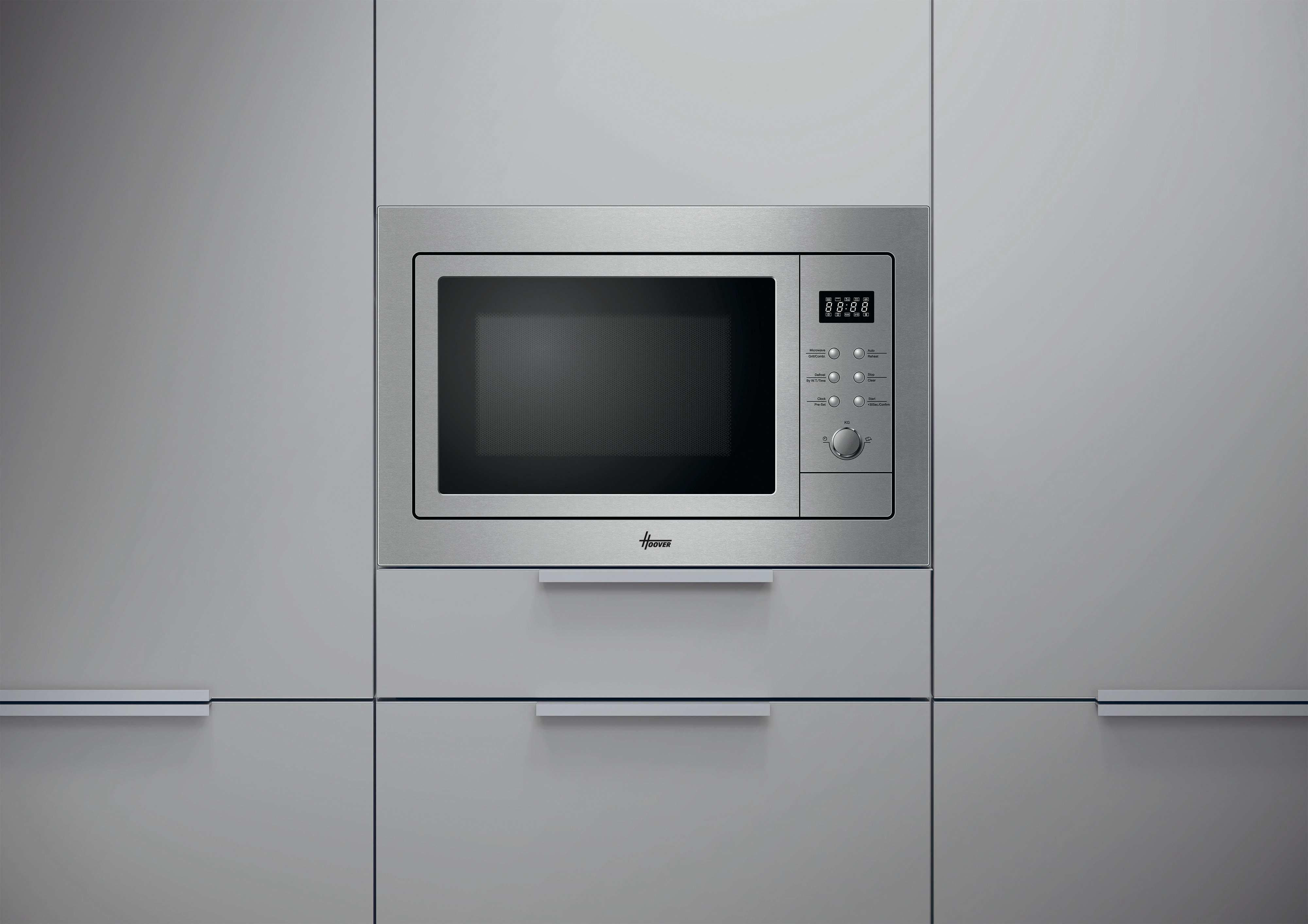 Un forno a microonde in acciaio inossidabile è integrato in un mobile grigio. Ha un display digitale e un pannello di controllo. Il logo Hoover è visibile.
