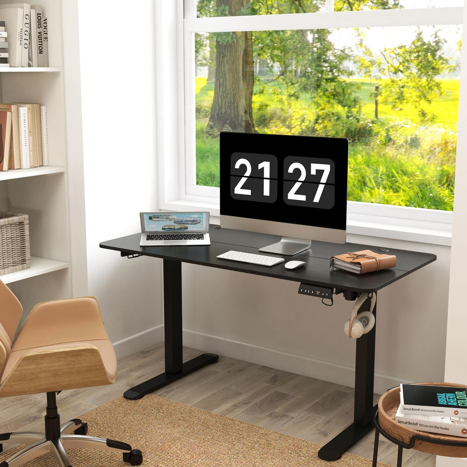 Ein Schreibtisch mit Monitor, der 21:27 anzeigt. Laptop, Tastatur, Maus und Kopfhörer liegen darauf. Ein Fenster zeigt eine grüne Landschaft.