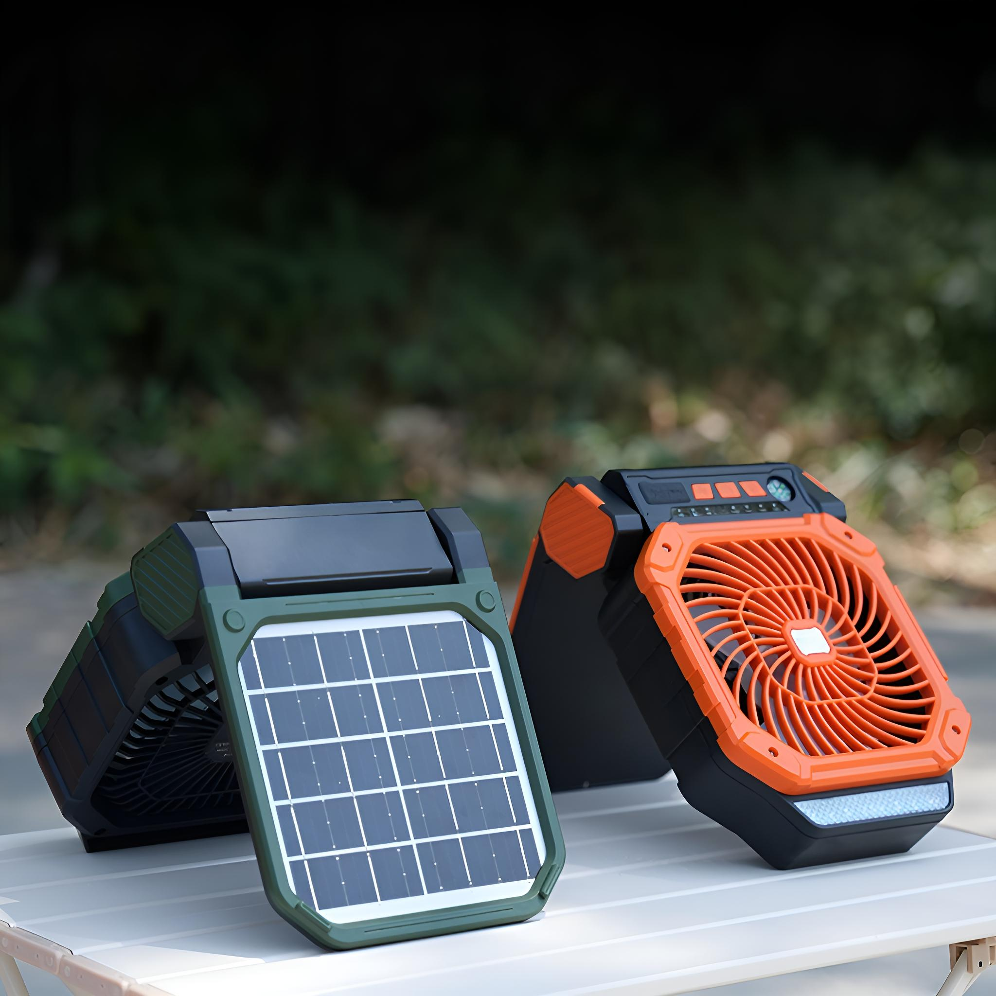 Zwei solarbetriebene Ventilatoren auf einem weißen Tisch. Einer ist grün mit einem Solarpanel, der andere orange. Verschwommener grüner Hintergrund.