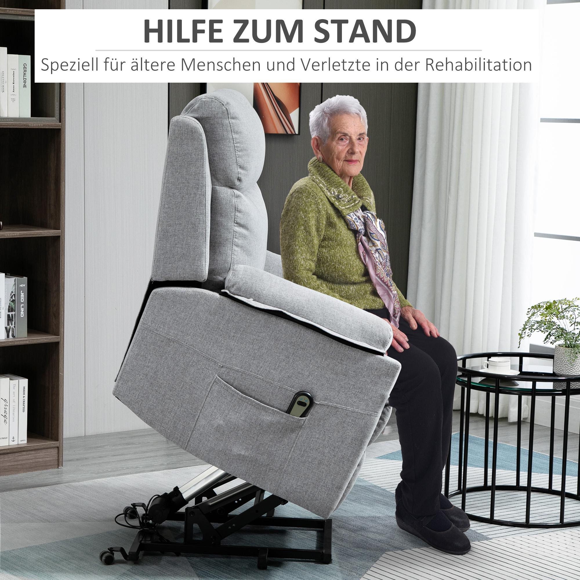 Eine ältere Frau sitzt in einem grauen Sessel. Der Stuhl ist angehoben. Es gibt einen Beistelltisch mit einer Pflanze und ein Bücherregal.