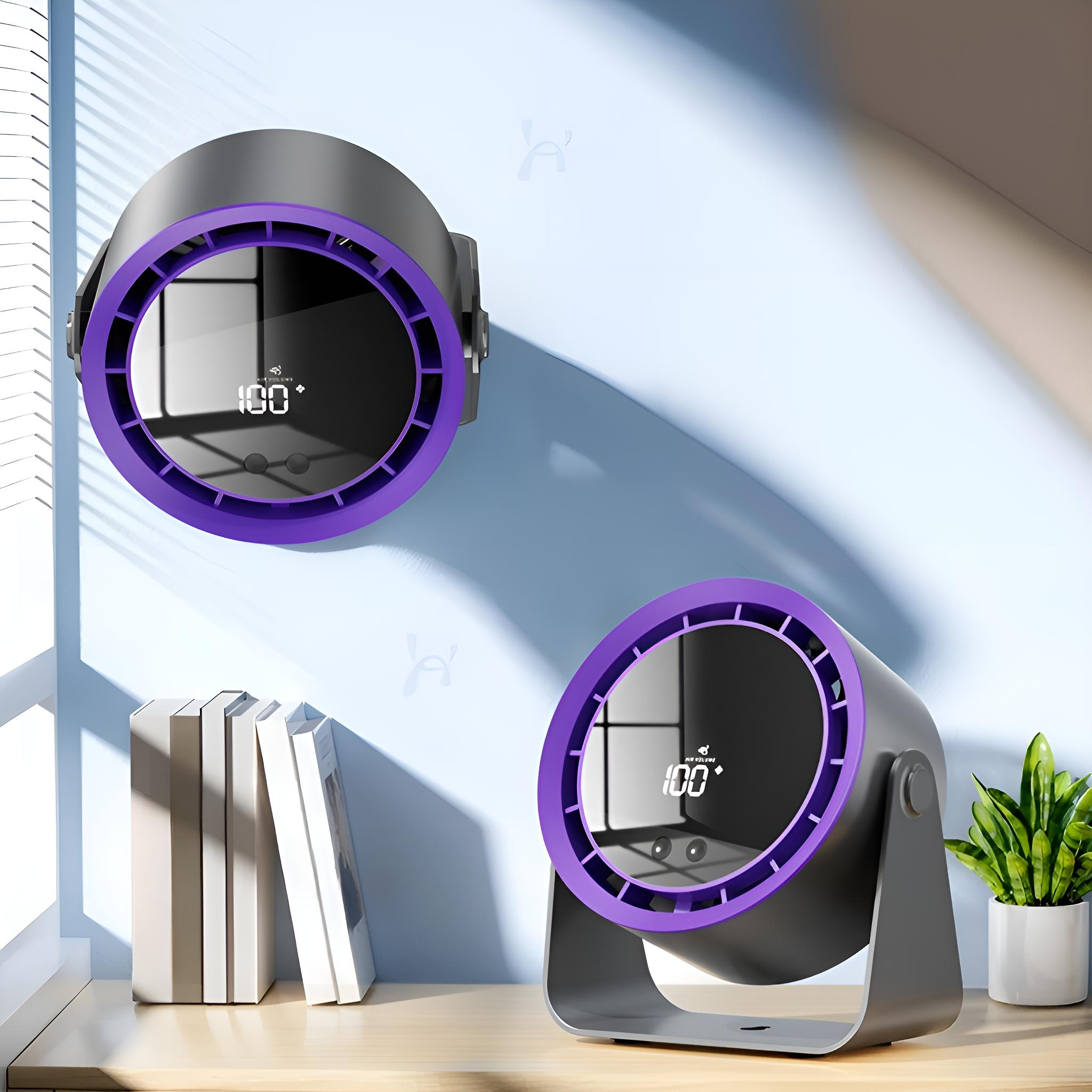 Zwei schwarze und violette Ventilatoren, einer an der Wand, der andere auf einem Schreibtisch mit Büchern und einer Pflanze.