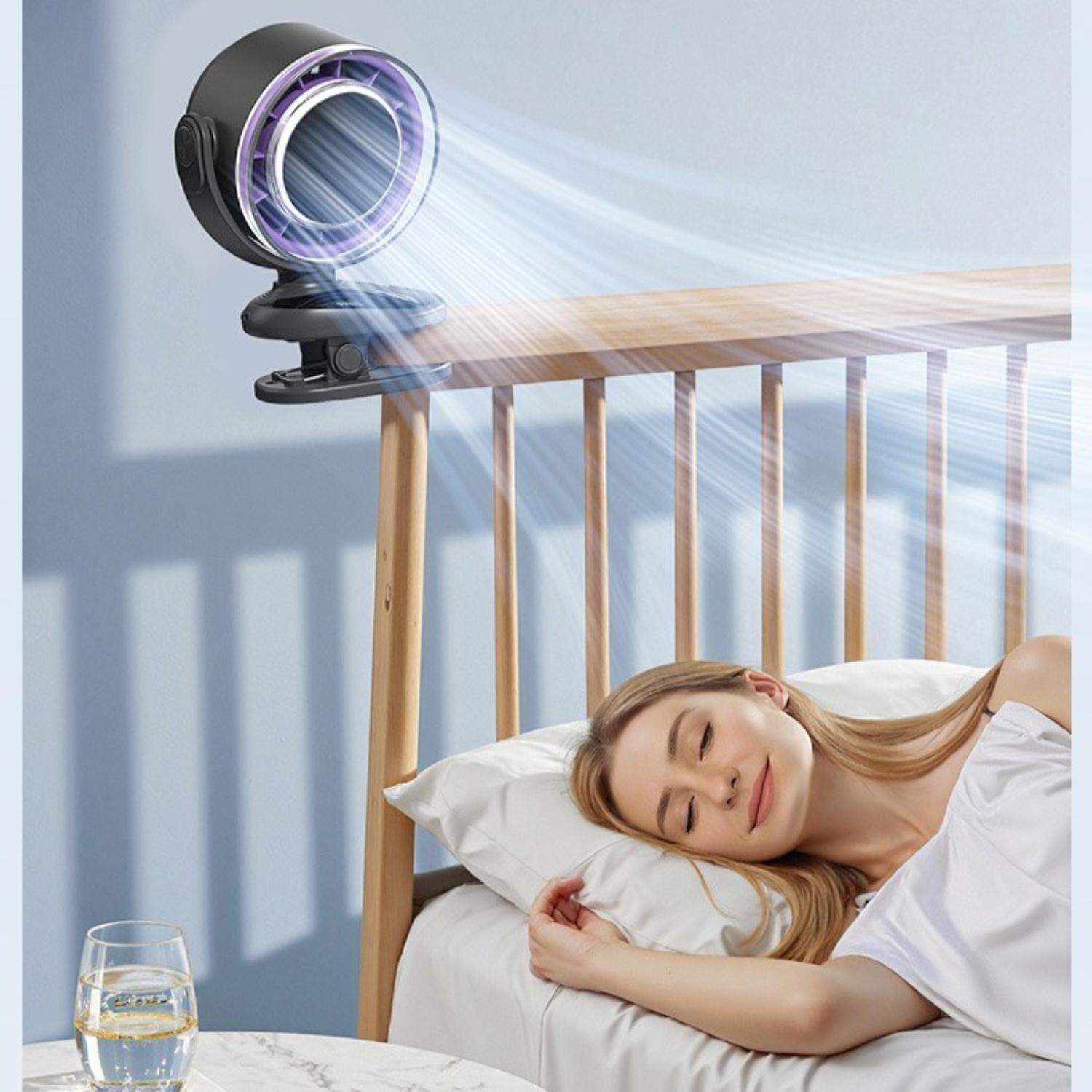Eine Frau schläft im Bett, ein Ventilator ist am Bettrahmen befestigt. Ein Glas Wasser steht auf einem Tisch neben dem Bett.