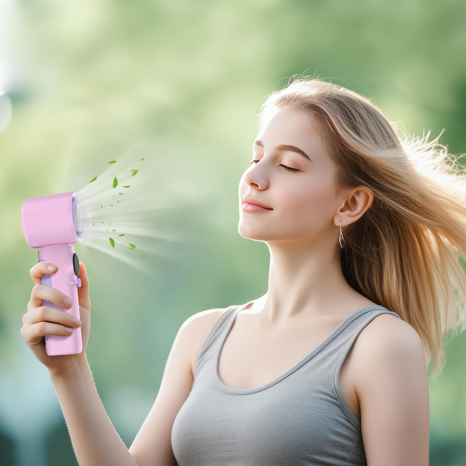 Frau mit geschlossenen Augen, rosa Ventilator, grüne Blätter, heller Hintergrund. Sie trägt ein graues Oberteil. Blondes Haar weht im Wind.