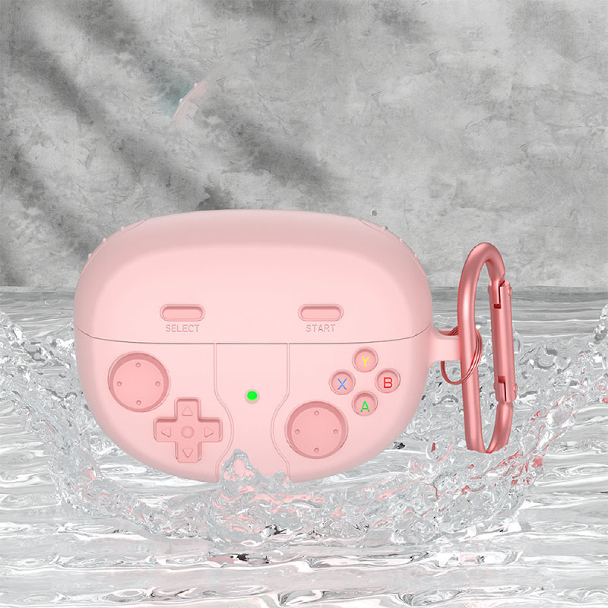 Eine rosa, spielcontrollerförmige Hülle für Ohrhörer. Es hat einen Metallverschluss und befindet sich vor einem Wasserspritzer-Hintergrund.