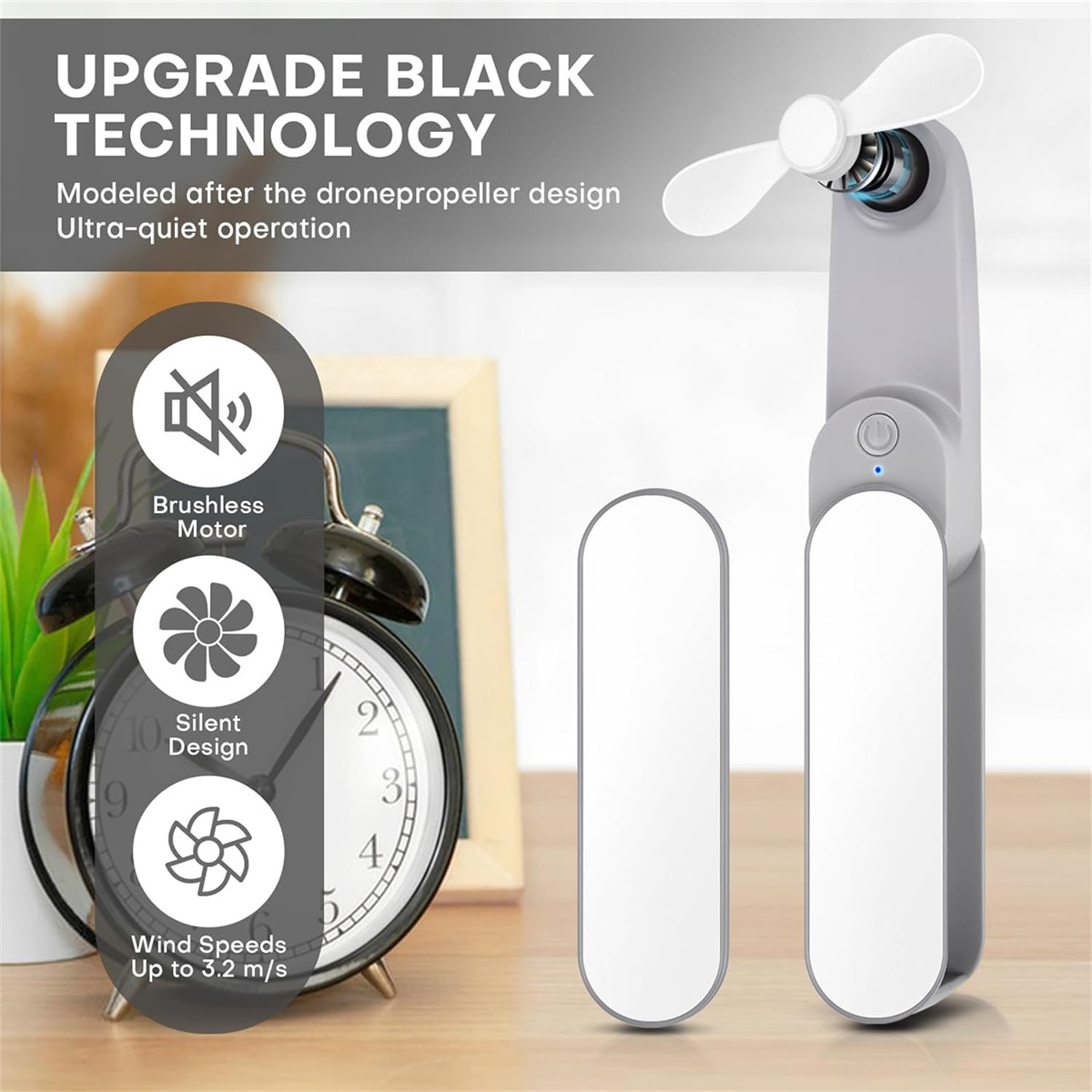 Das Bild zeigt einen grauen Handventilator mit weißen Flügeln. Der Text hebt die verbesserte schwarze Technologie hervor, bürstenloser Motor und leises Design.
