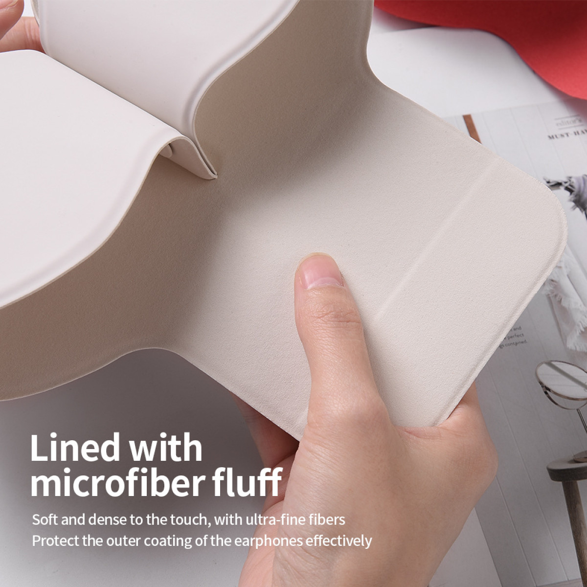 Eine Hand hält eine beige Hülle mit weichem Mikrofasergewebe offen. Text: 'Mit Mikrofaserflusen gefüttert'. Im Hintergrund ein Magazin.