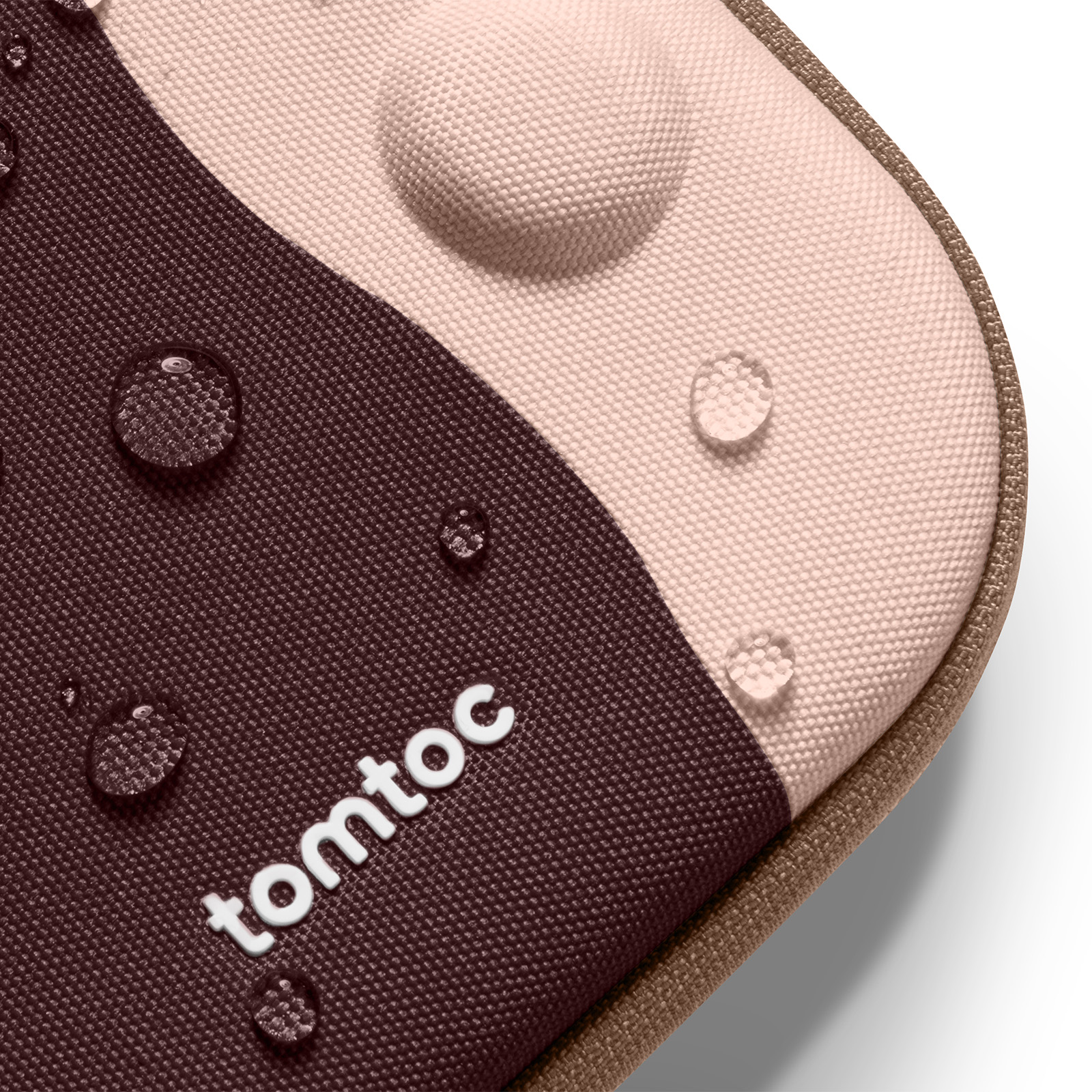 Zbliżenie na etui tomtoc z kroplami wody. Etui ma brązowe i różowe sekcje. Logo jest białe.