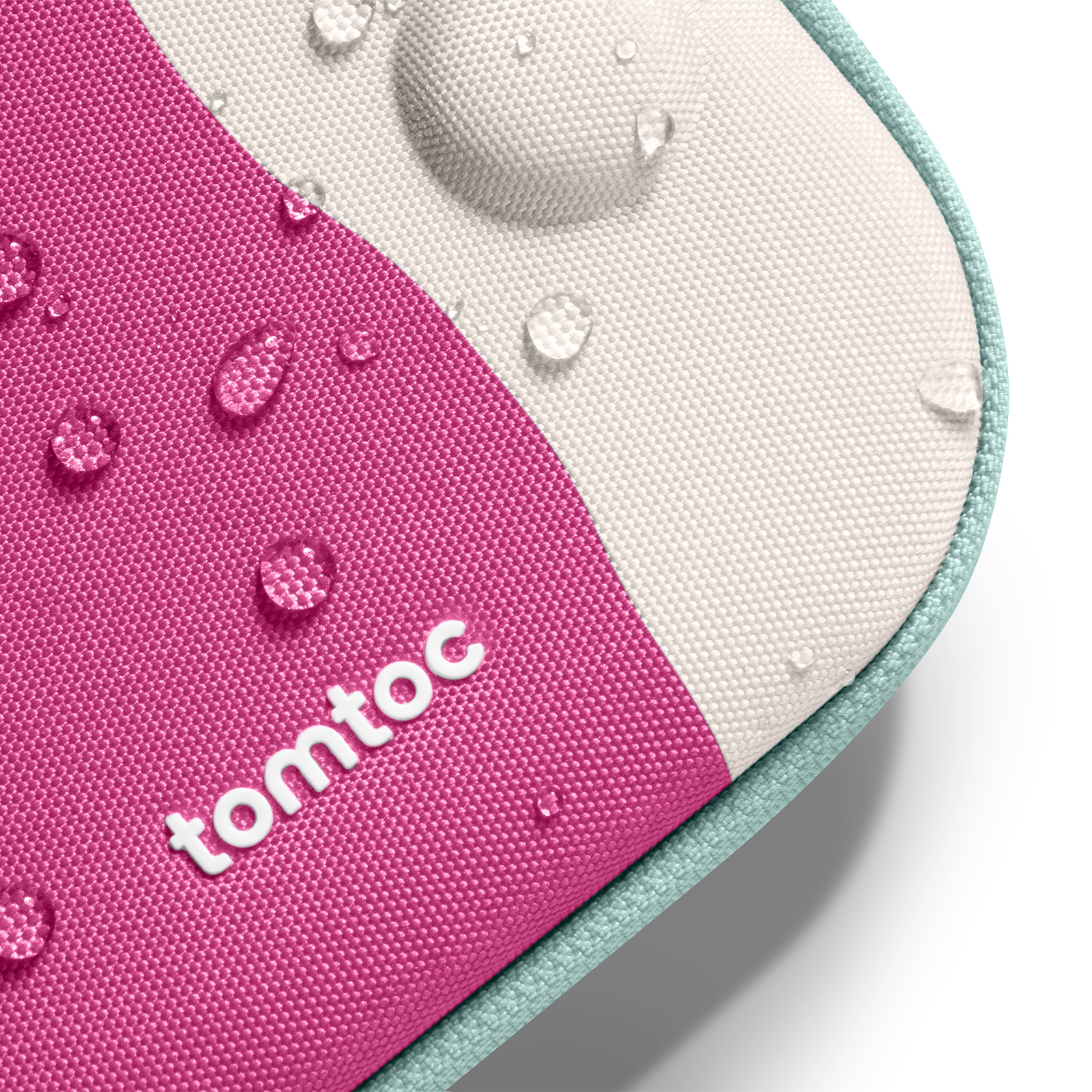 Zbliżenie różowej i białej tkaniny z kroplami wody. Widoczna marka "tomtoc". Krawędź jest jasnoniebieska.