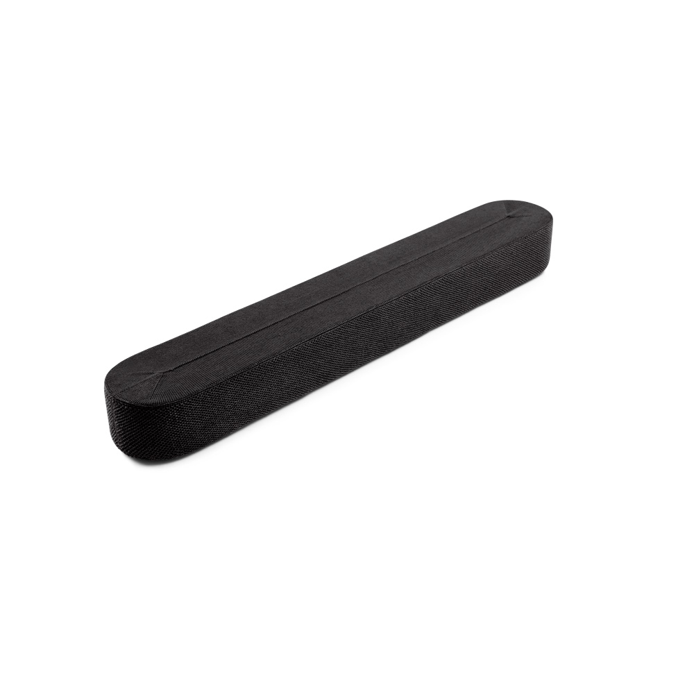 Une barre de son noire et oblongue repose sur une surface blanche. La barre de son est rectangulaire avec des extrémités arrondies et une surface texturée.