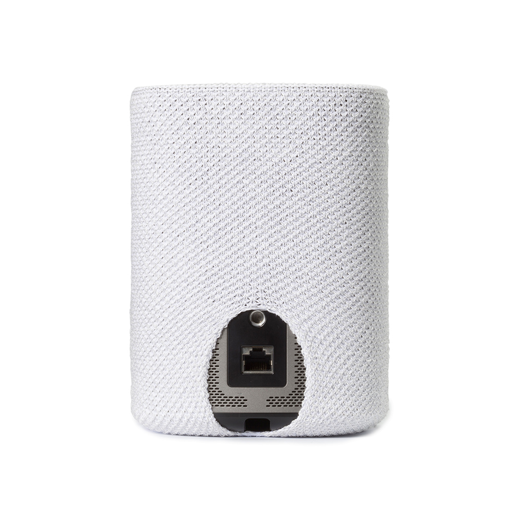 Un appareil cylindrique blanc est partiellement recouvert d'une housse blanche texturée. Une ouverture révèle un port noir et un panneau métallique.