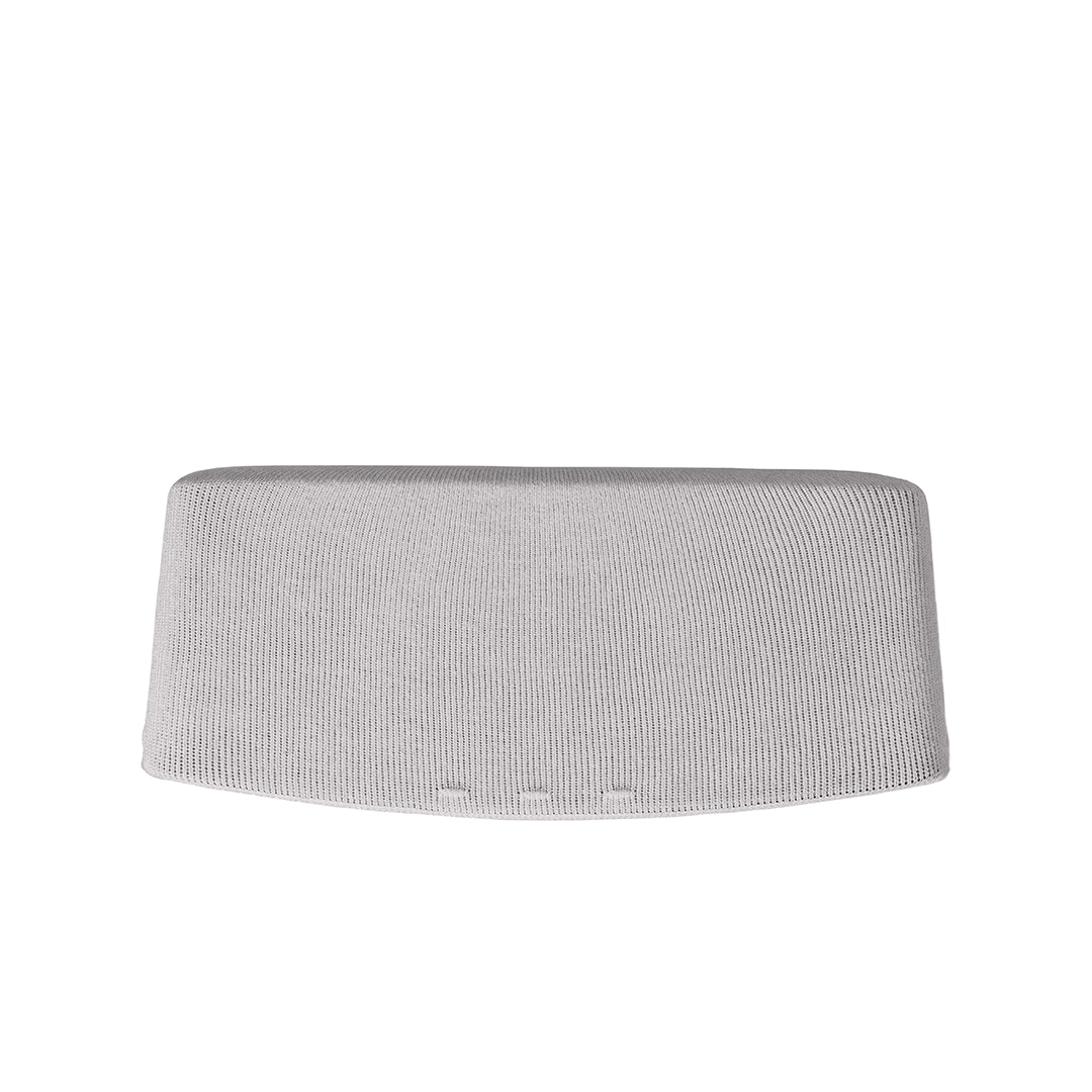 Un objet gris cylindrique avec une texture tricotée. Il a un dessus incurvé et une base plate, sur fond blanc.