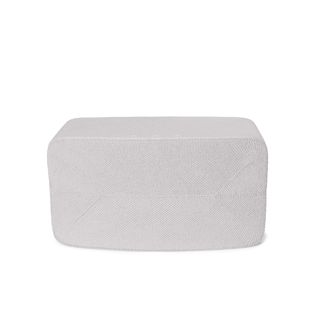 Un pouf rectangulaire gris clair avec une surface texturée, sur fond blanc. Le pouf est bien éclairé et centré.