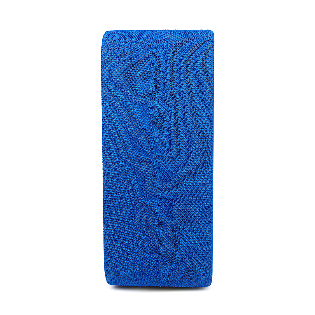 Un objet bleu rectangulaire, peut-être du tissu, est orienté verticalement sur un fond blanc. La texture semble tricotée.