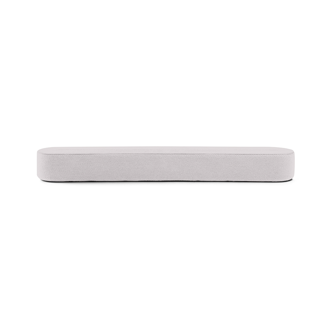 Un banc rectangulaire rembourré gris clair sur fond blanc. Le banc est la mise au point principale, simple et moderne.