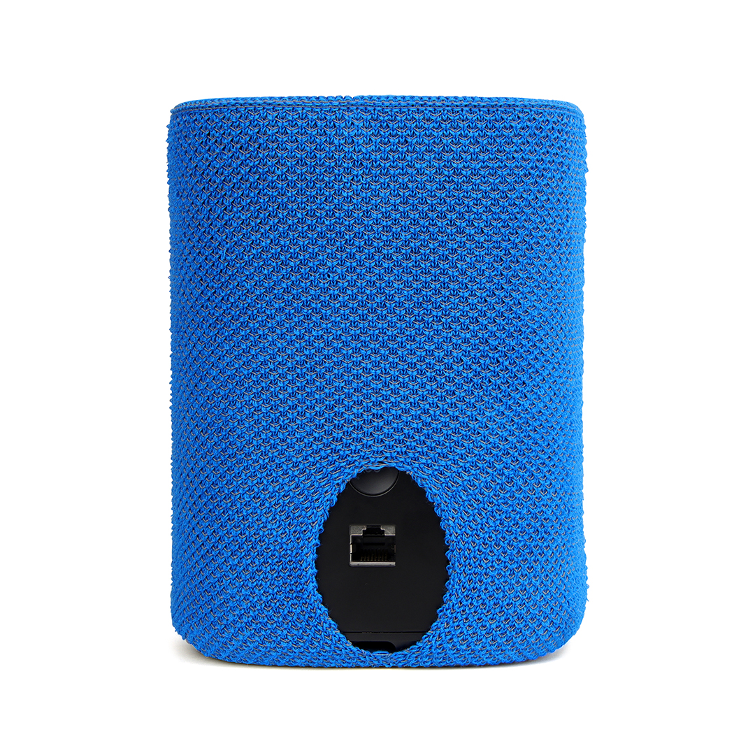Un haut-parleur cylindrique bleu recouvert d'un tissu tricoté. Un panneau noir à l'arrière révèle des ports, dont un port Ethernet.