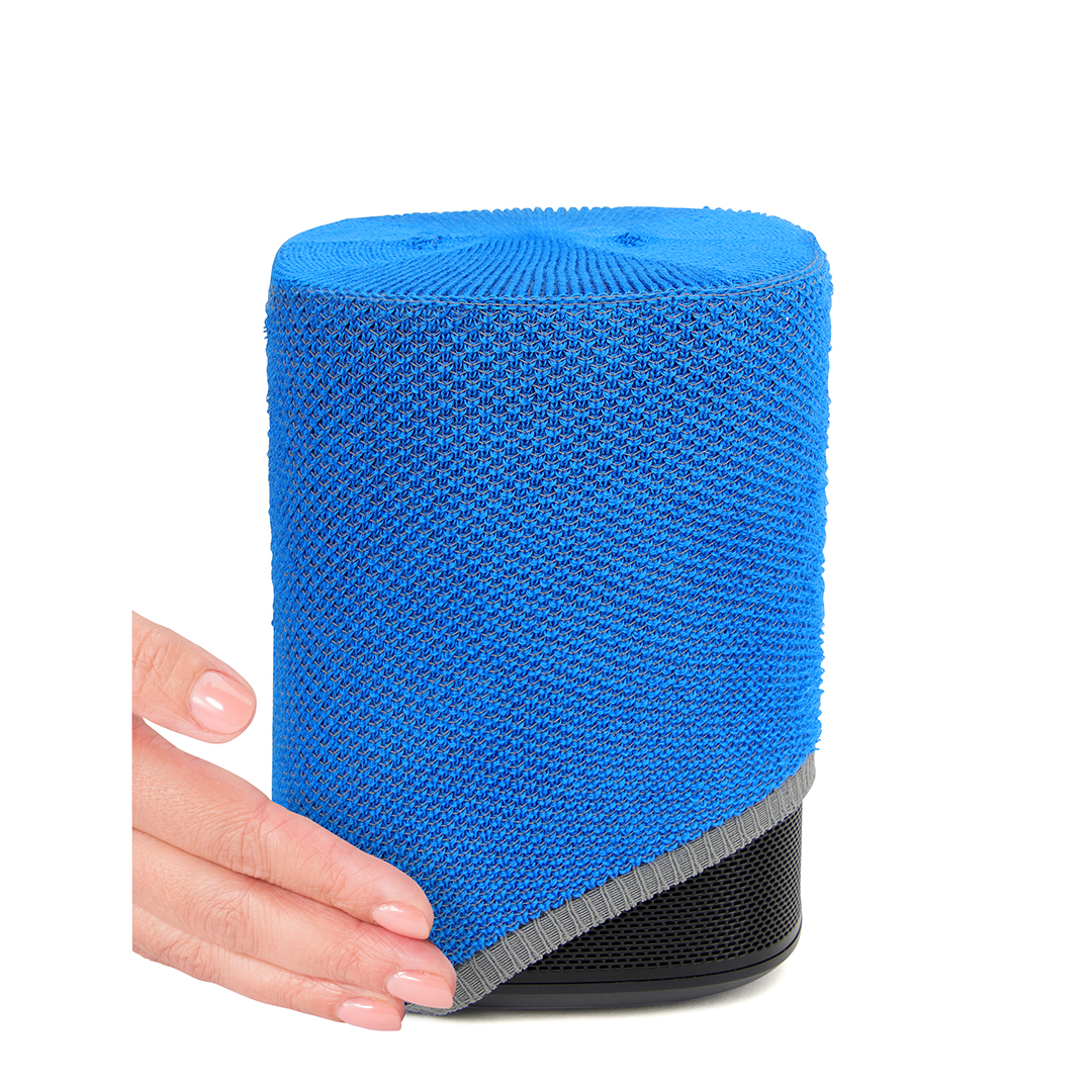 Haut-parleur bleu avec une housse texturée, une bordure grise et une base noire. Une main touche le haut-parleur. Fond blanc.
