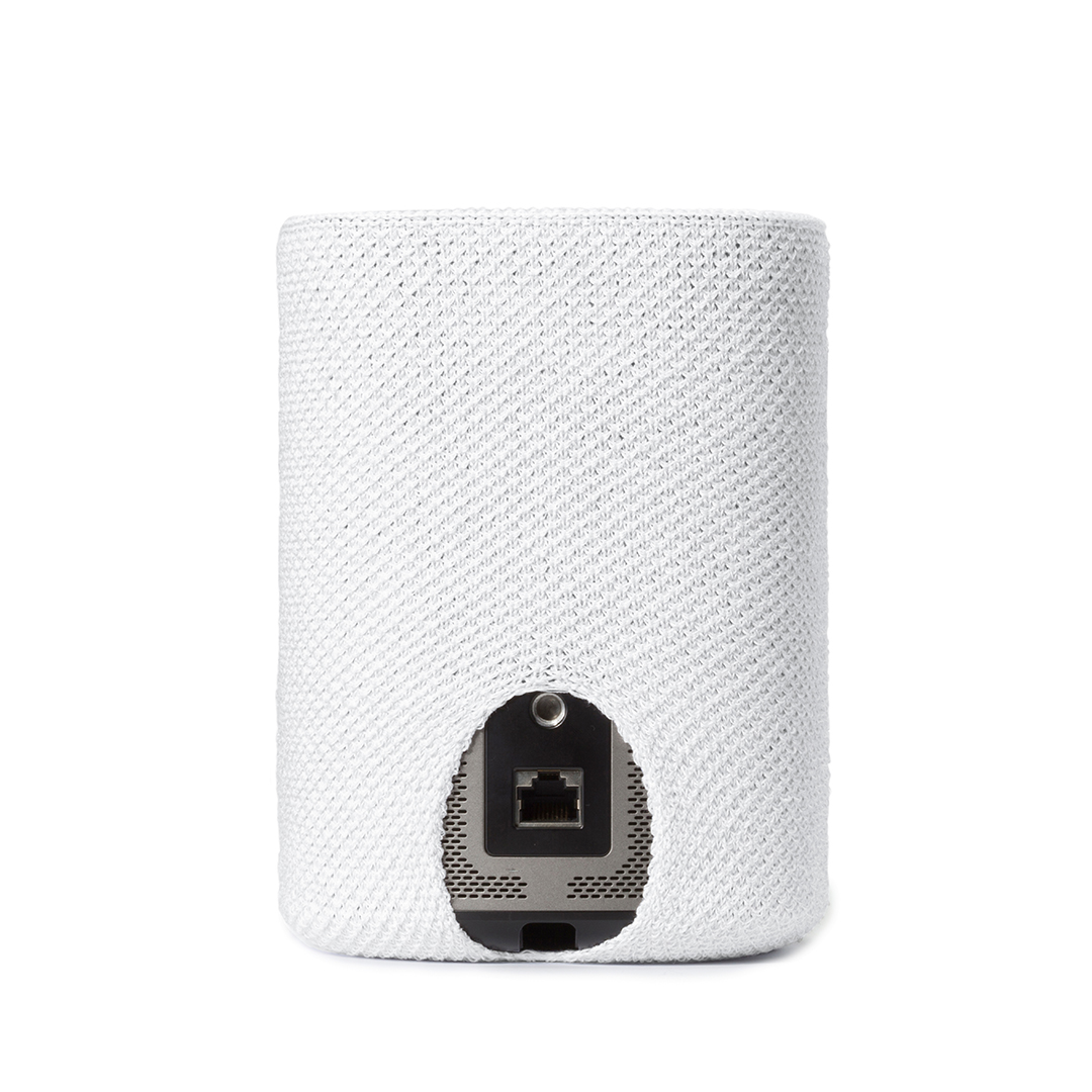 Un appareil cylindrique blanc, partiellement recouvert d'un tissu en maille blanc. L'appareil a un port visible en bas.