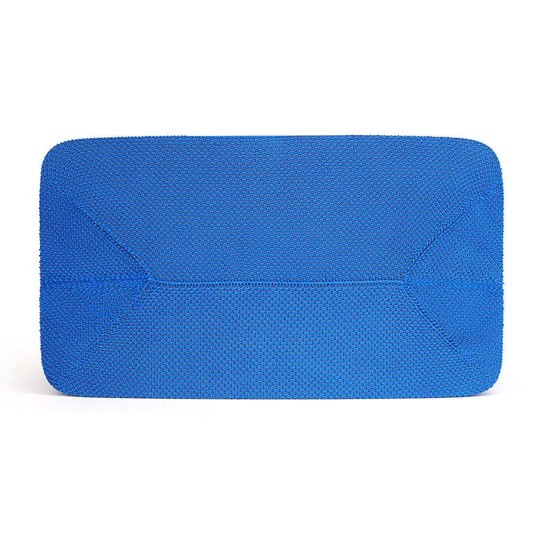 Un objet rectangulaire bleu vif avec des coins arrondis. La surface a une texture tissée. Le fond est blanc.