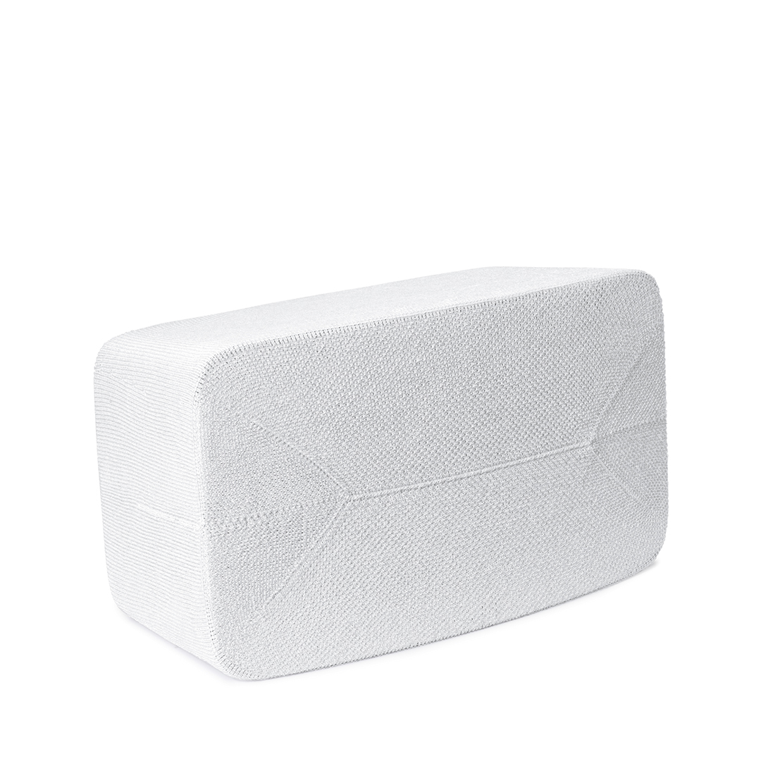 Un objet blanc et rectangulaire avec une surface texturée est vu sur un fond blanc. L'objet semble être un sac.