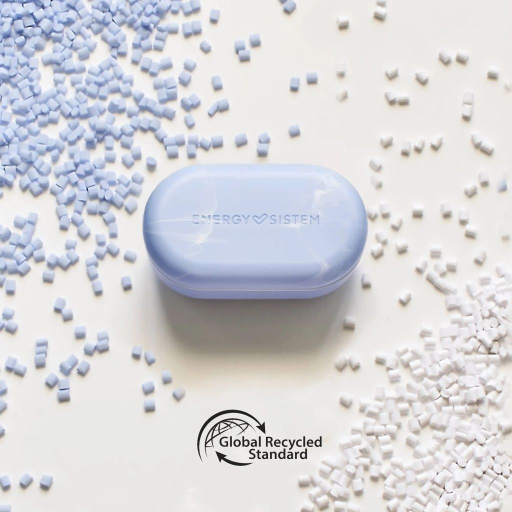 Custodia Energy Sistem azzurra circondata da pellet blu e bianchi. Il logo Global Recycled Standard è in basso.