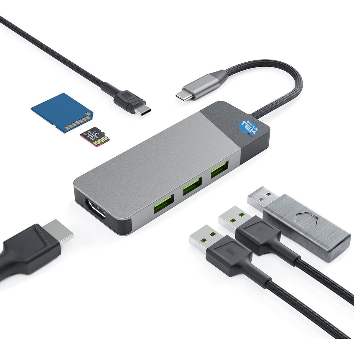 Ein USB-C-Hub mit verschiedenen Anschlüssen, USB-Kabeln, SD-Karten und einem USB-Laufwerk auf weißem Hintergrund.