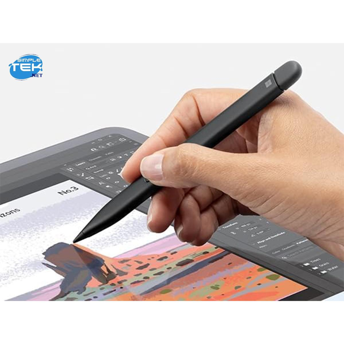 Una mano tiene una penna nera sopra un tablet. Lo schermo del tablet mostra un'immagine. Lo sfondo è sfocato.