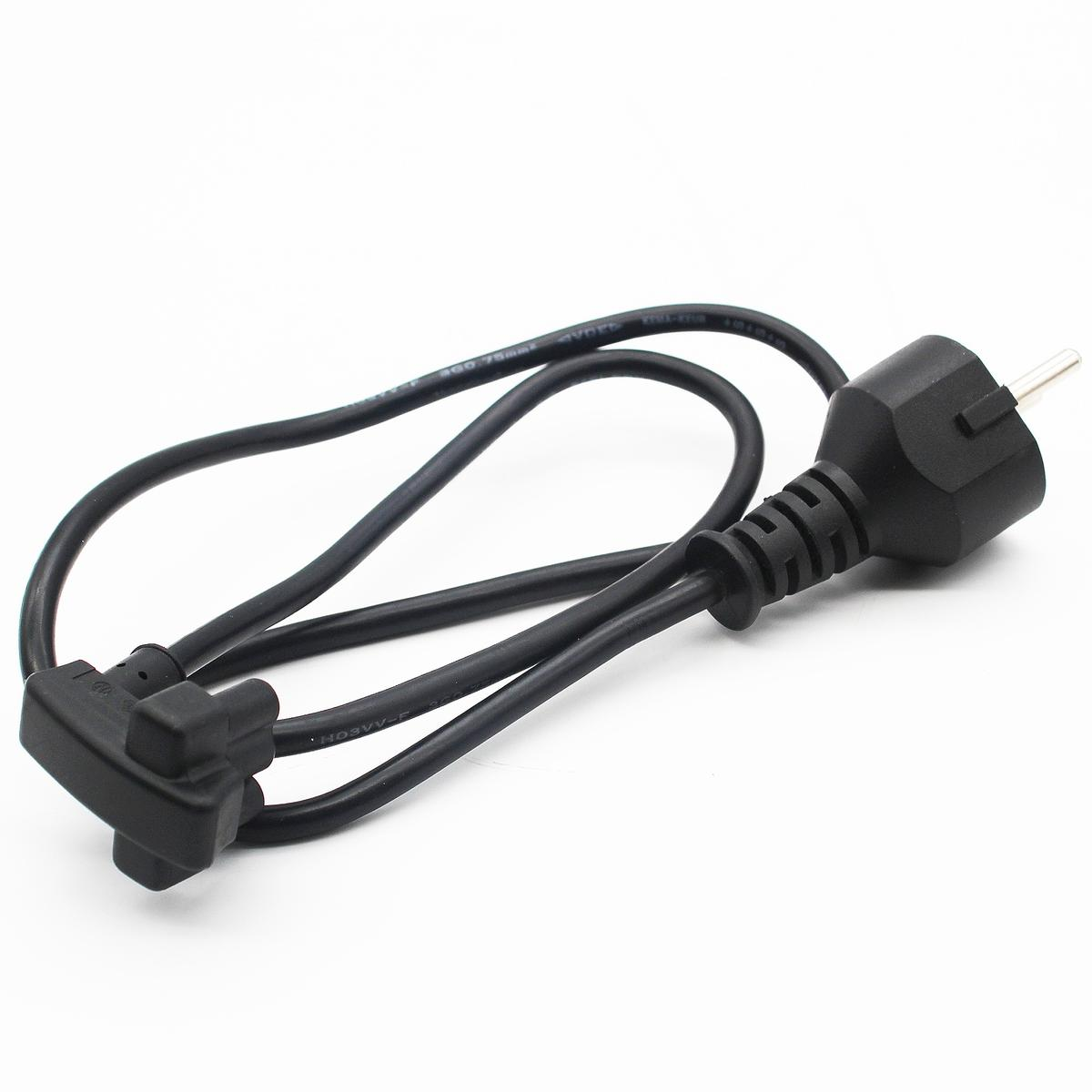 Un cable de alimentación negro con un enchufe europeo se encuentra sobre una superficie blanca. El cable tiene un conector hembra y un enchufe macho.