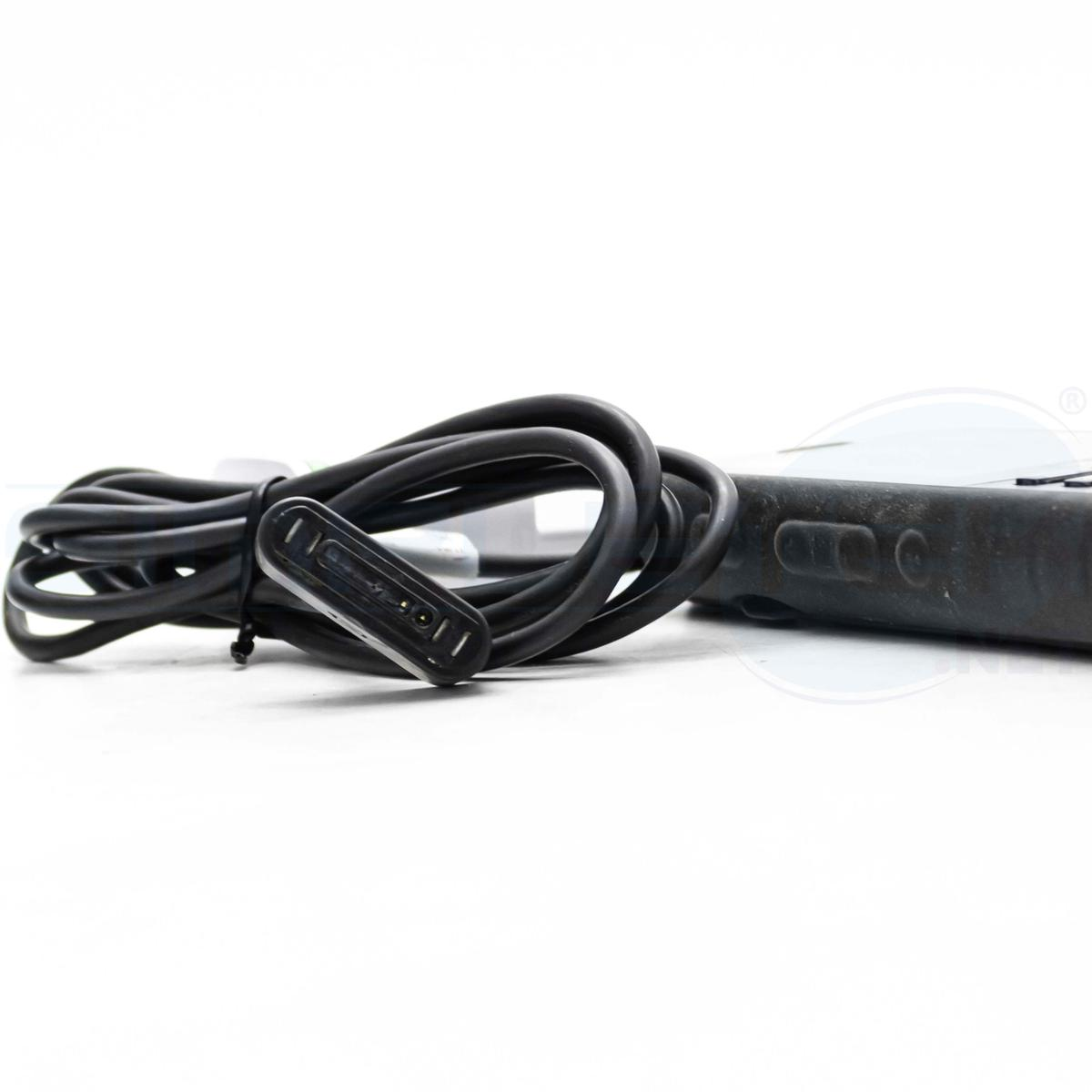 Un cavo di ricarica nero con connettore magnetico è arrotolato. Una porzione di un dispositivo nero è visibile a destra.