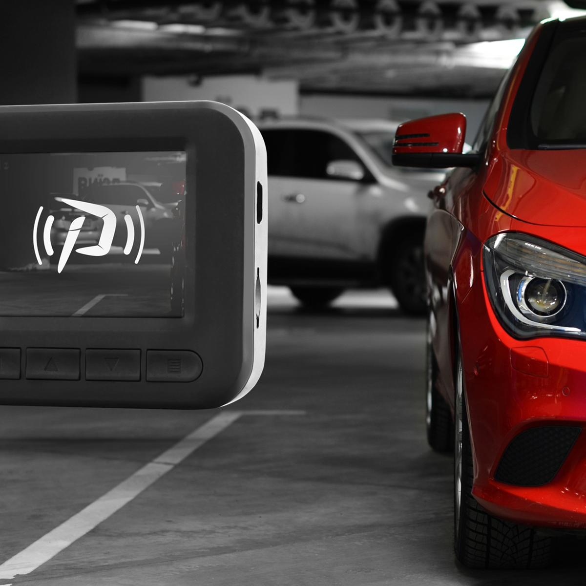 Una pantalla de sensor de aparcamiento muestra una imagen de un coche. Un coche rojo está aparcado a la derecha. El fondo muestra un coche blanco en un garaje.