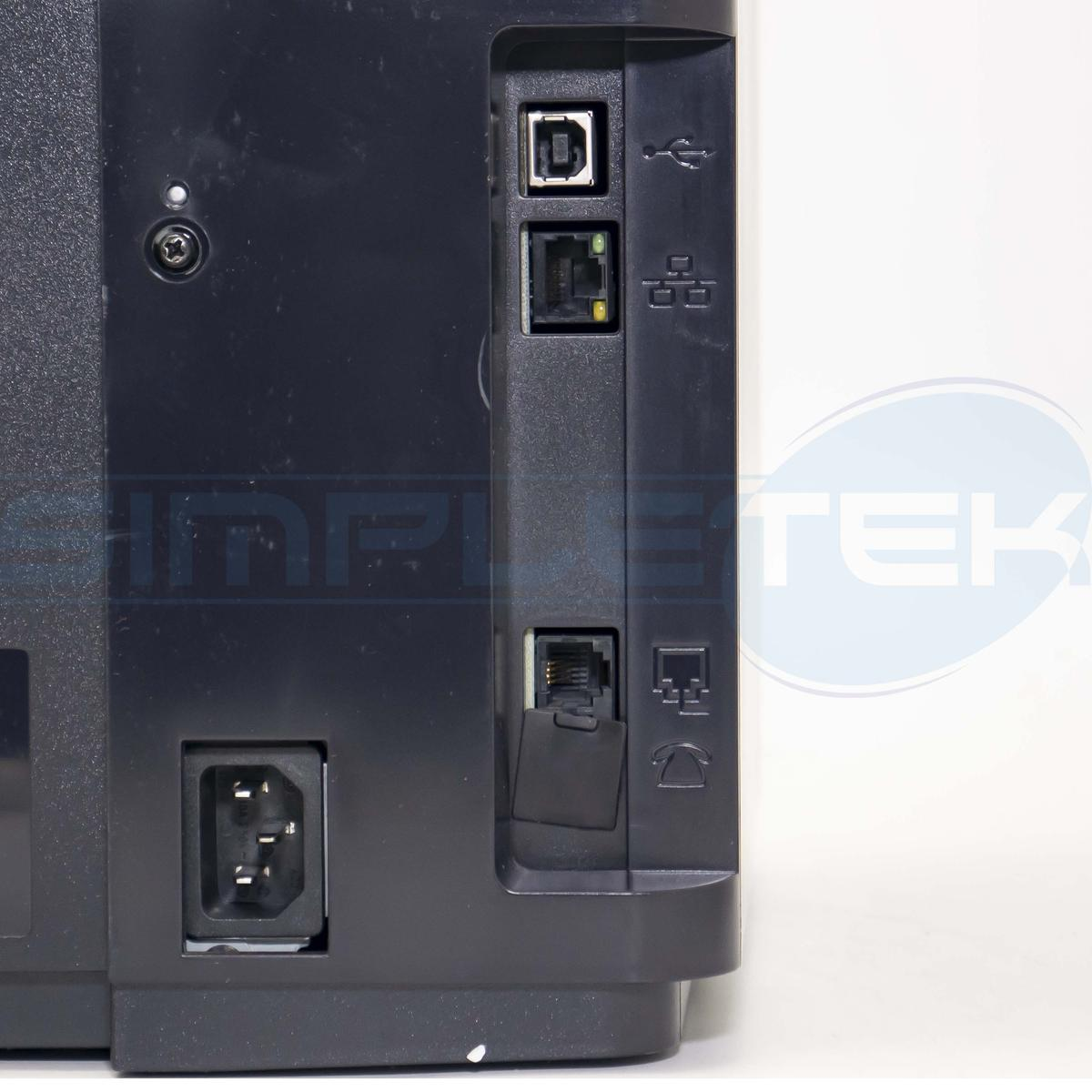 Primo piano del pannello posteriore di una stampante nera. Porte visibili: USB, Ethernet e ingresso alimentazione. Sfondo bianco.