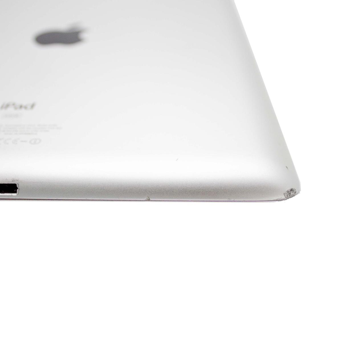 Srebrny iPad, lekko pochylony, na białym tle. Widoczne logo Apple. Krawędź iPada ma kilka śladów.