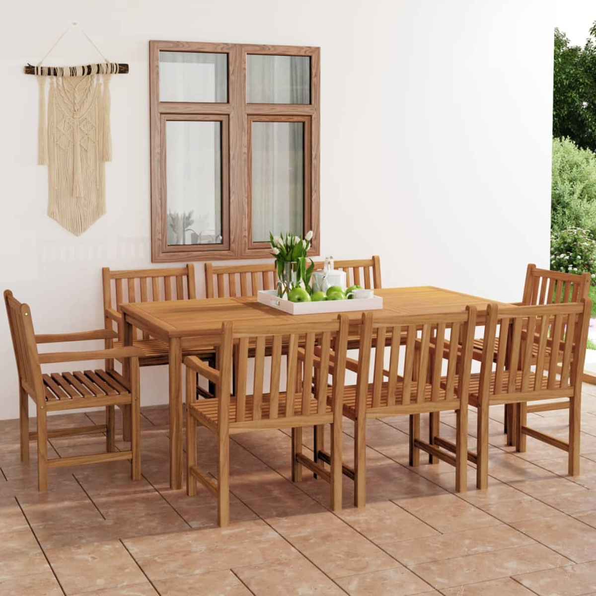 Essgarnitur im Freien mit Holztisch und Stühlen. Ein Wandbehang aus Makramee und ein Fenster sind im Hintergrund. Äpfel und Blumen auf dem Tisch.