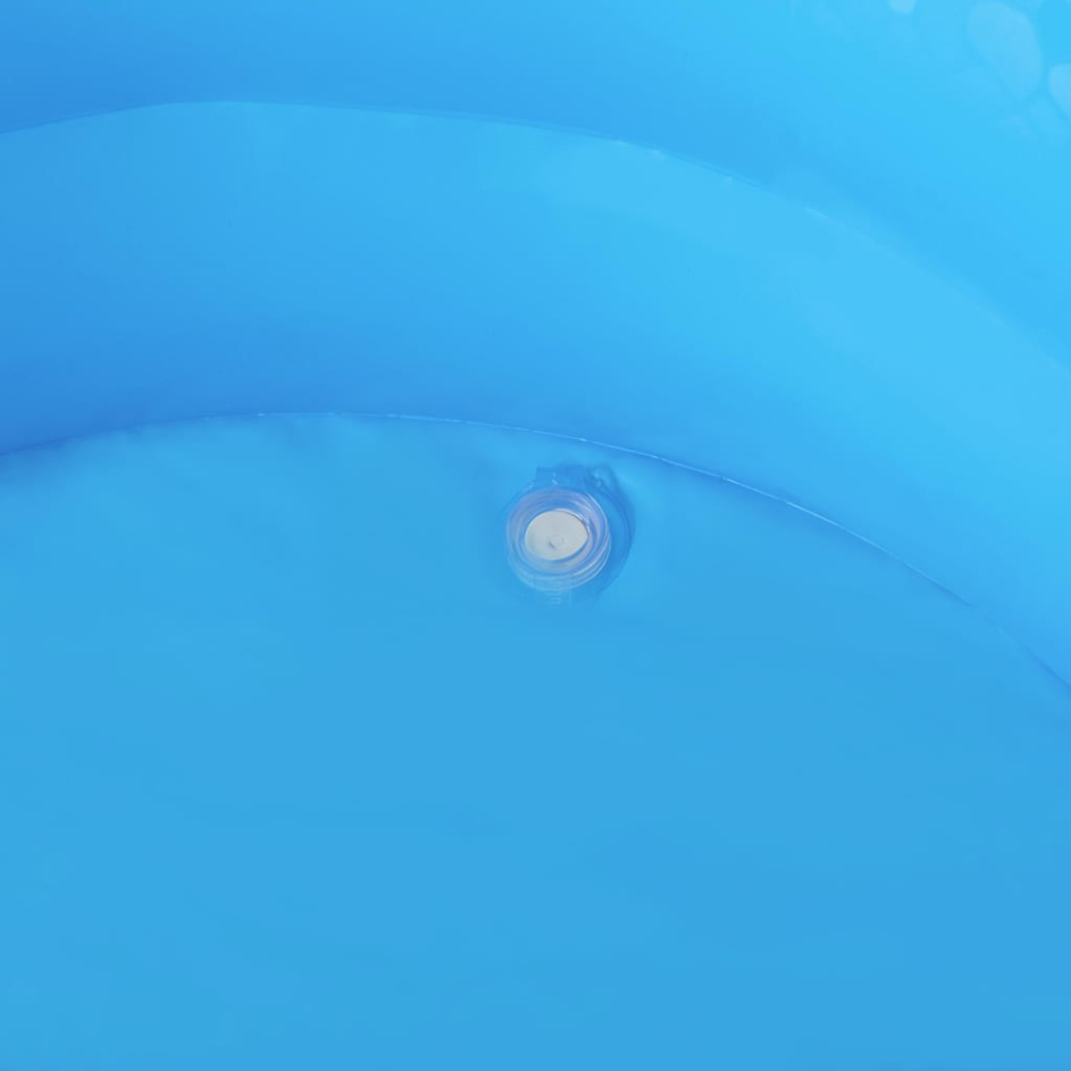 Een close-up van een opblaasbaar blauw zwembad. Een witte afvoer met een heldere ring bevindt zich in de rechterbenedenhoek.