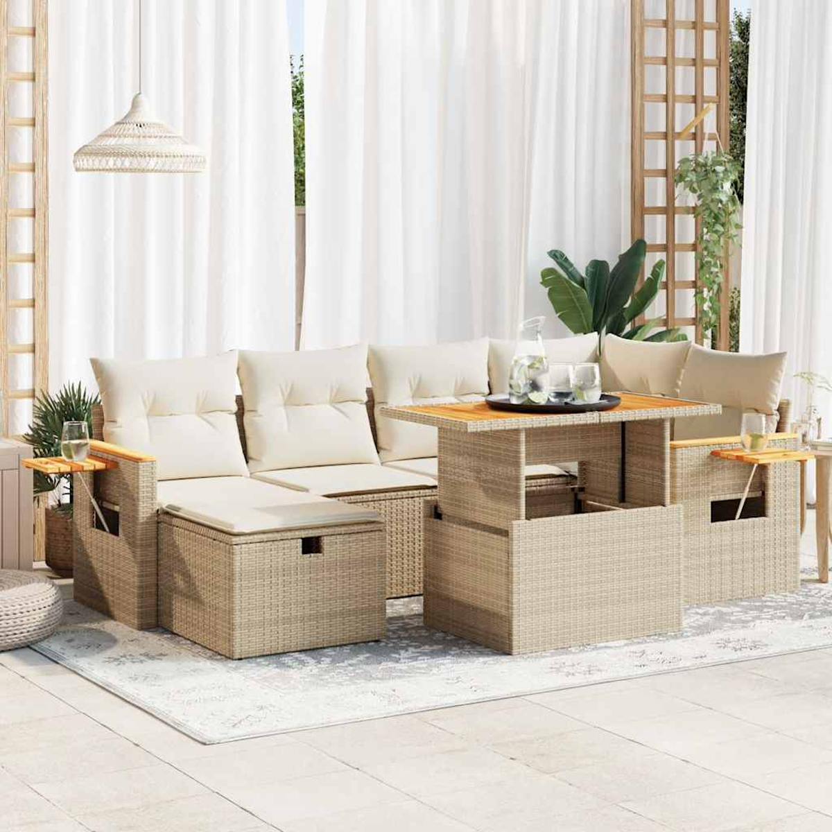 Gartenmöbel-Set aus Rattan auf einer Terrasse. Enthält Sofa mit Kissen, Tisch mit Getränken und weiße Vorhänge im Hintergrund.