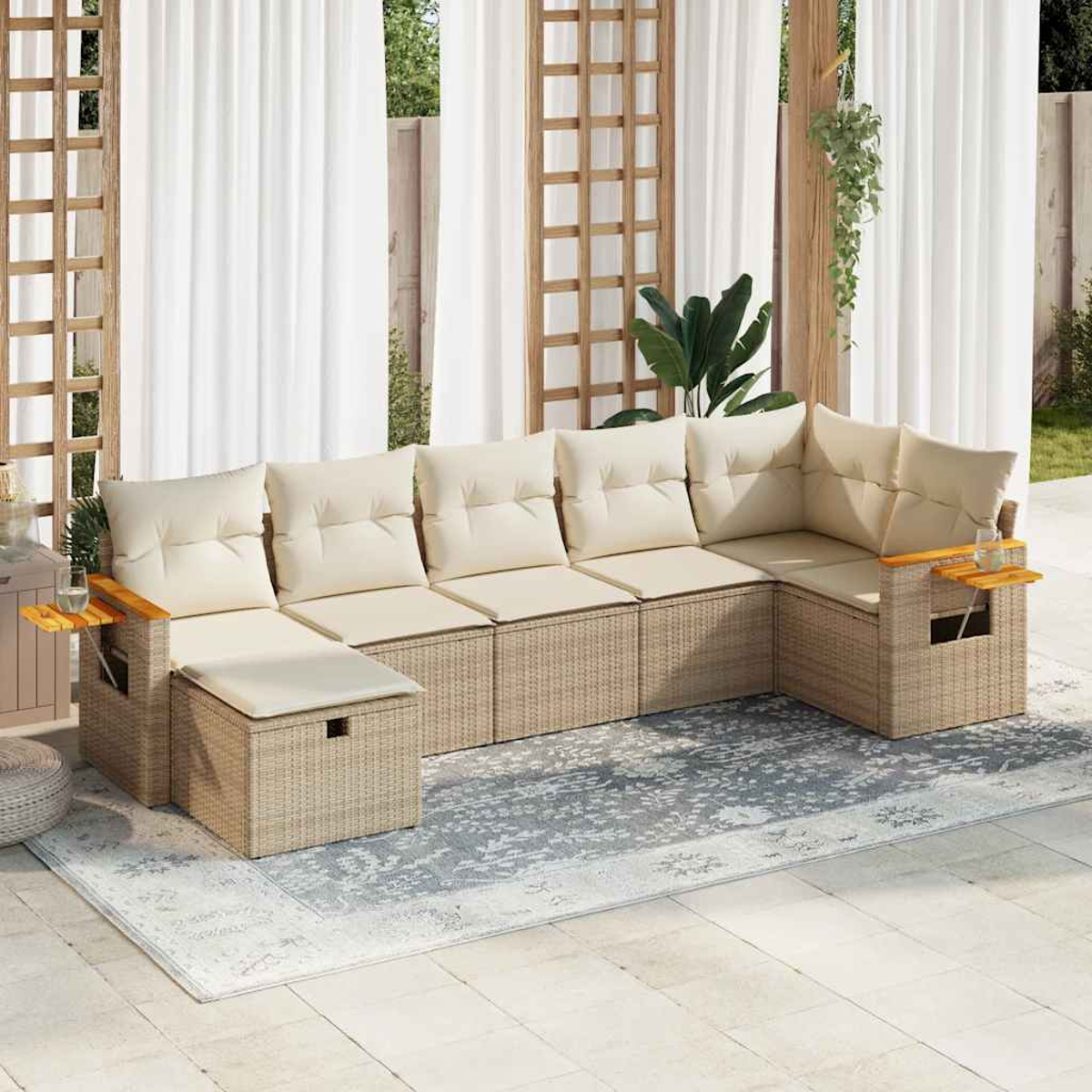 Divano angolare da esterno con cuscini beige su un tappeto grigio. Tende bianche e traliccio in legno sullo sfondo.