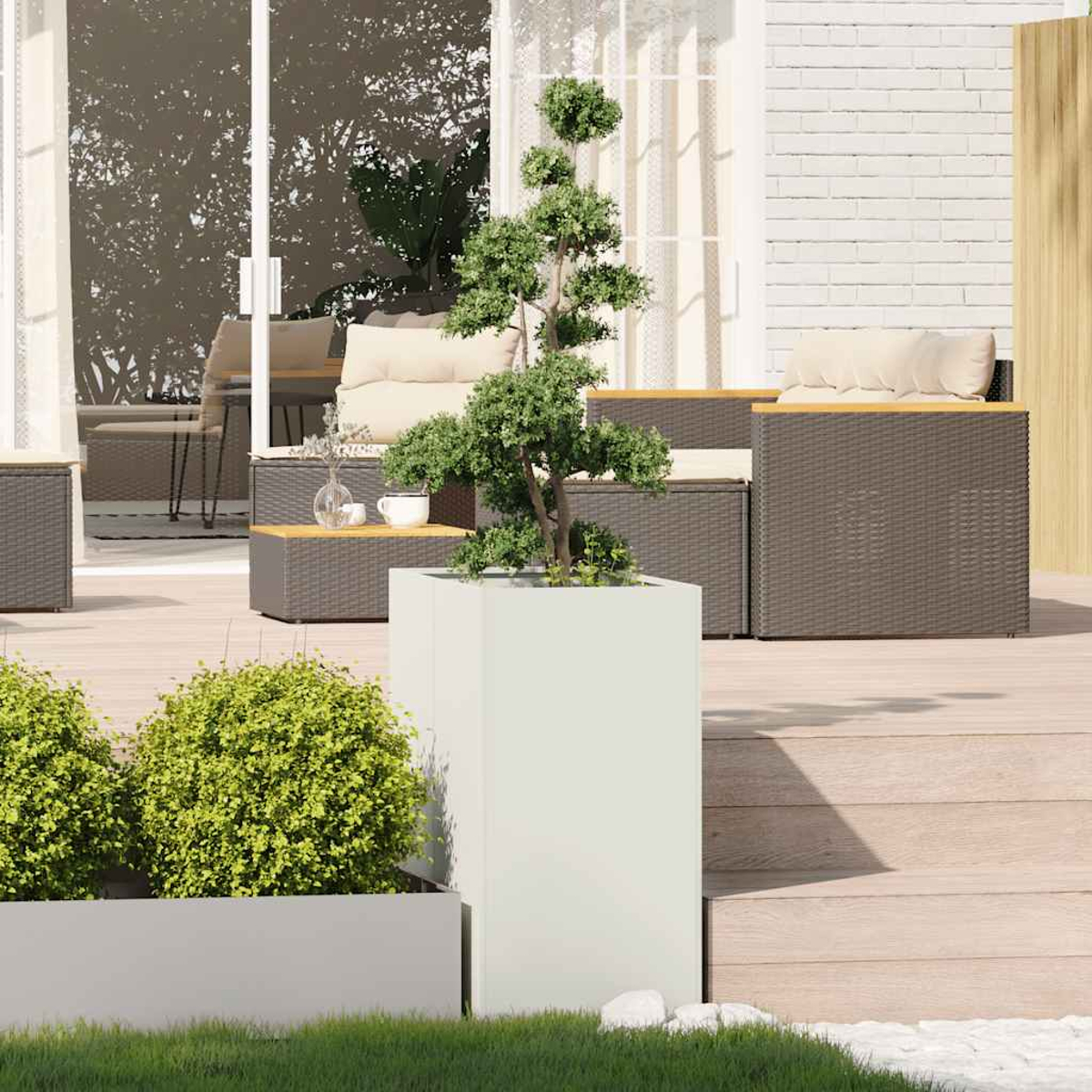 Scena del patio con bonsai in vaso, mobili in vimini e piccoli cespugli verdi. Fioriera bianca, terrazza in legno ed erba verde visibili.