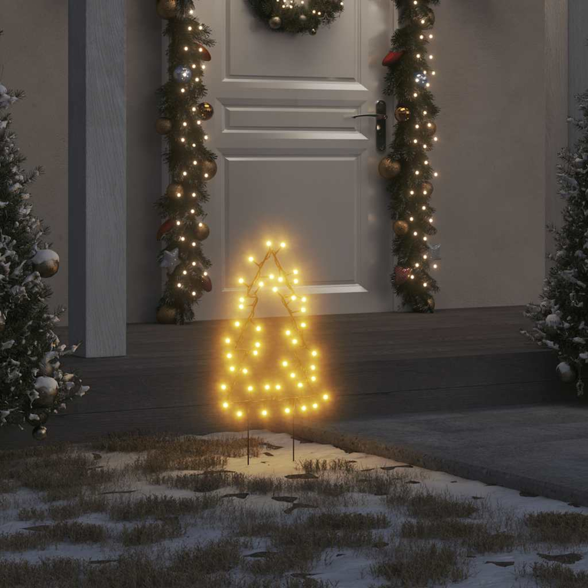Ein beleuchteter Weihnachtsbaum steht auf verschneitem Boden. Girlanden und ein Kranz schmücken die Tür. Bäume mit Schnee an den Seiten.