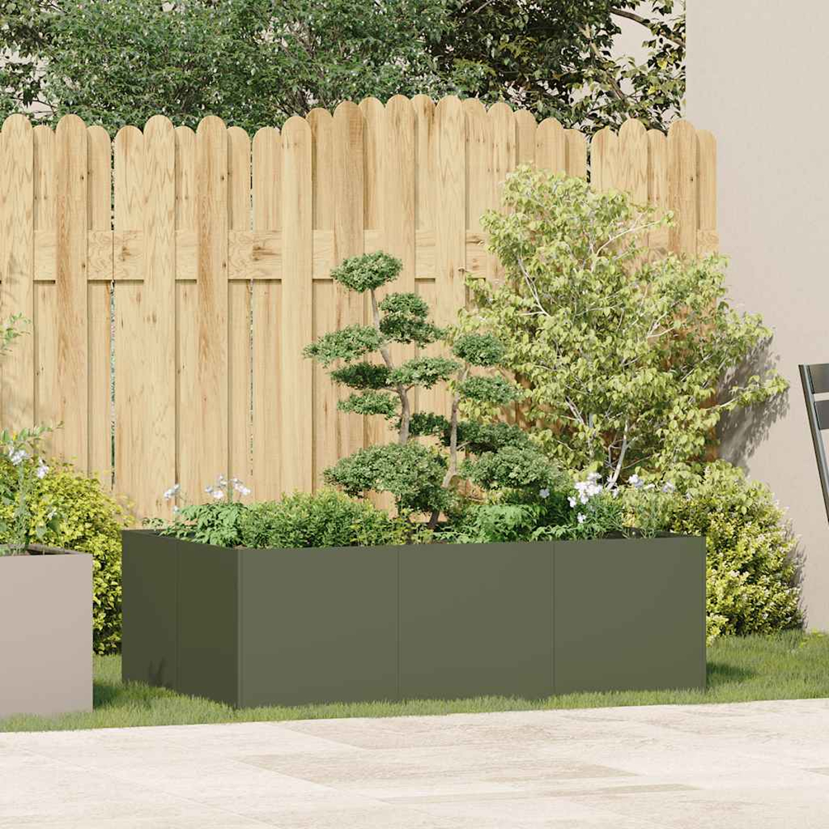 Una scena di giardino con una staccionata in legno e una grande fioriera verde piena di piante. Cespugli e alberi piccoli sullo sfondo.