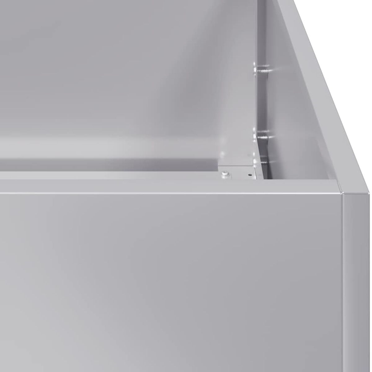 Nahaufnahme eines grauen Metallbehälters. Ecke und Seite sind mit Nieten und einer Naht sichtbar. Die Oberfläche ist glatt.
