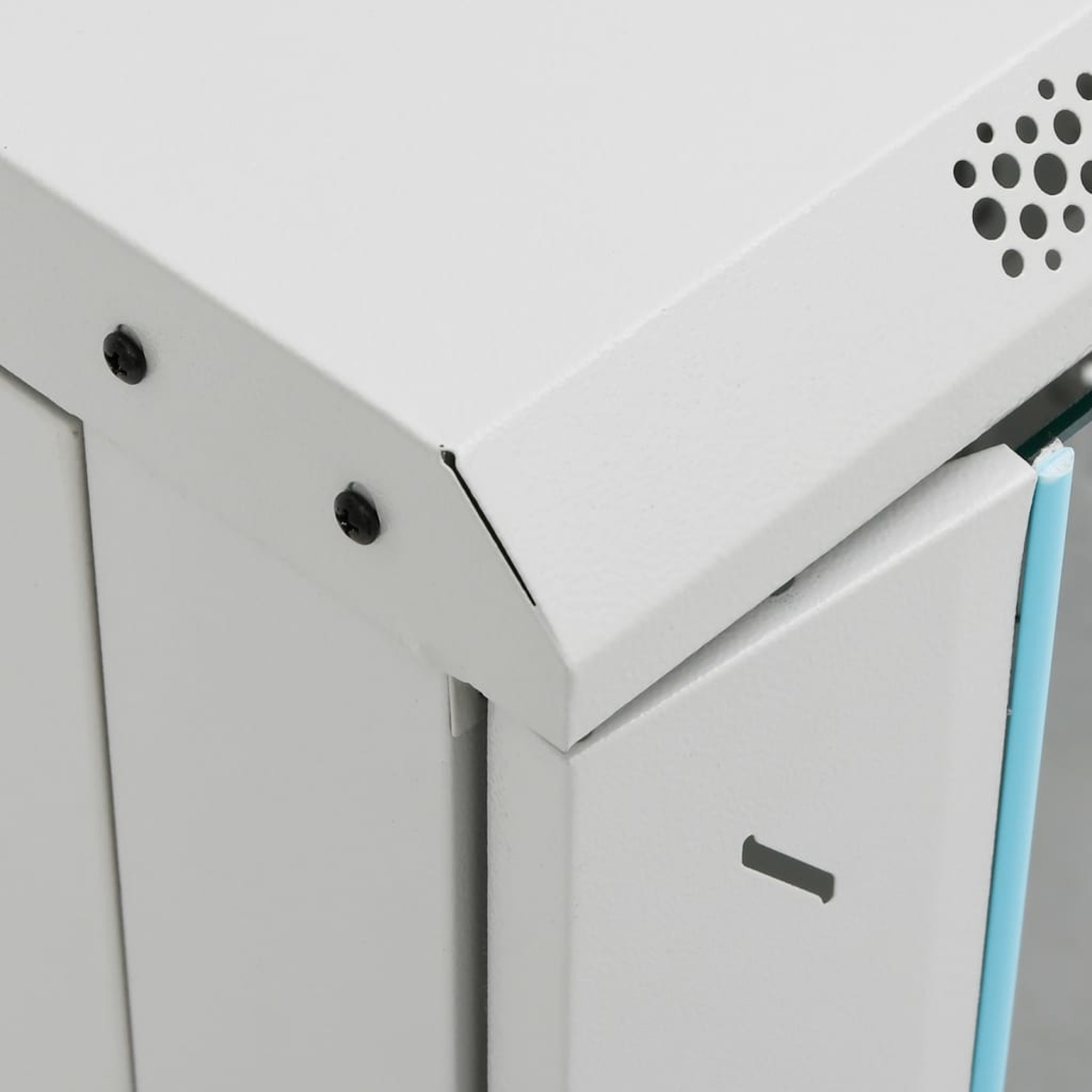 Nahaufnahme einer weißen Metalleckschranke. Schrauben, eine Entlüftung und eine blaue Kante sind sichtbar. Der Schrank scheint neu zu sein.