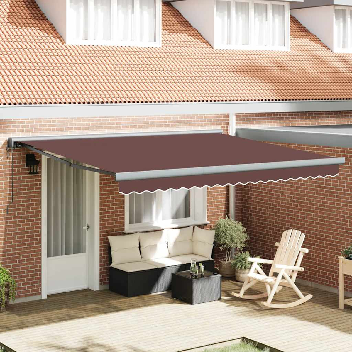 Tenda da sole marrone sopra un patio con posti a sedere, sedia a dondolo e piante in vaso. Muro di mattoni e tetto di tegole sullo sfondo.