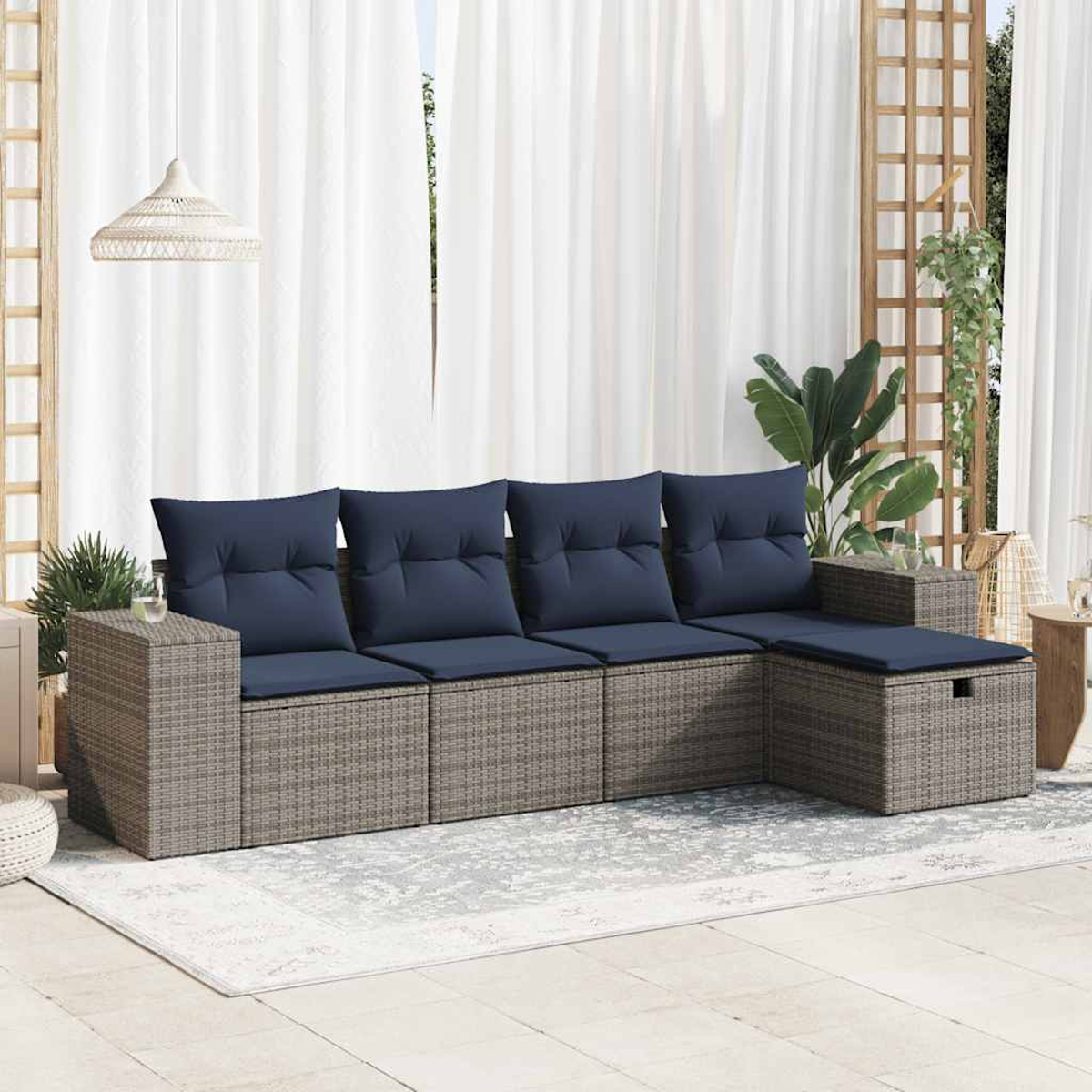 Outdoor-Ecksofa mit grauem Webgestell und marineblauen Kissen. Weiße Vorhänge und Pflanzen im Hintergrund.