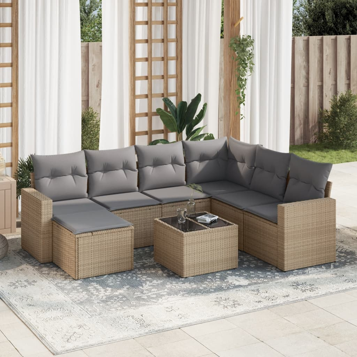 Outdoor-Ecksofa mit grauen Kissen und einem kleinen Tisch auf einem Teppich. Vorhänge und Holzkonstruktion im Hintergrund.