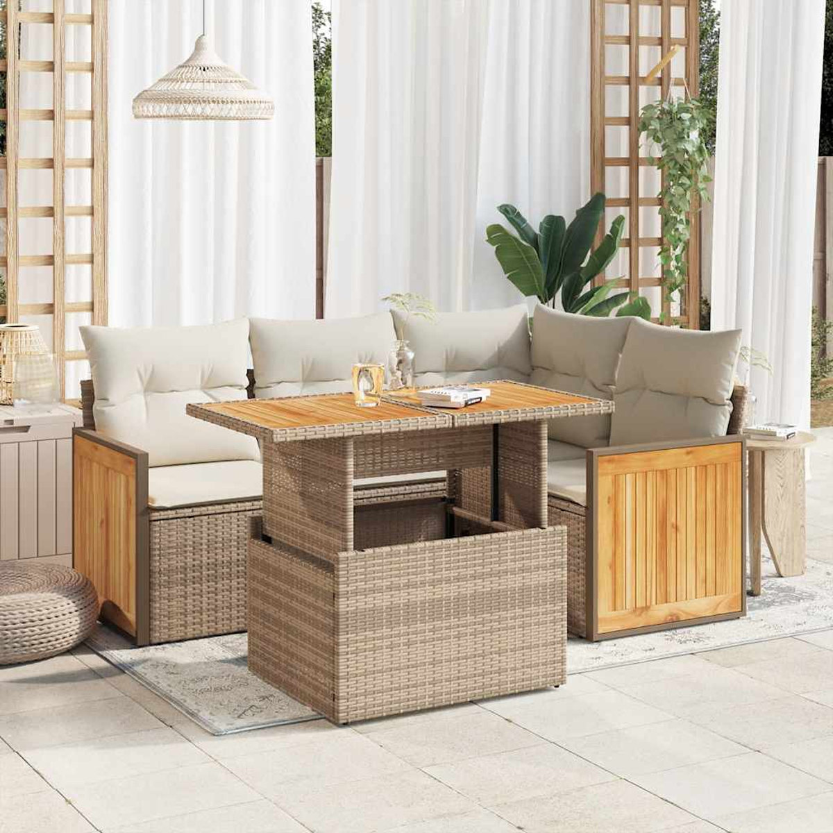 Set da patio con tavolo intrecciato, due divani con cuscini e un tappeto. Sono visibili tende bianche e una lampada a sospensione.