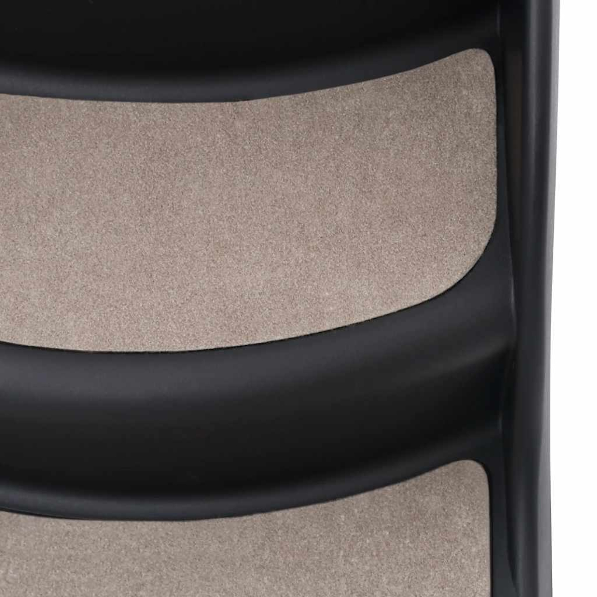Nahaufnahme einer schwarzen, gebogenen Struktur. Beige strukturierte Paneele sind in den Kurven sichtbar. Der Hintergrund ist weiß.