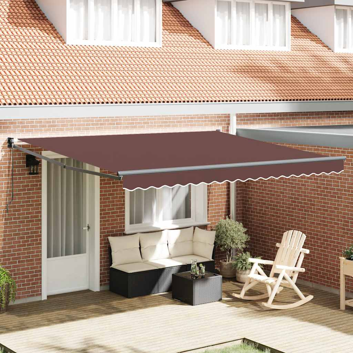 Eine Terrasse mit brauner Markise. Es gibt eine Couch, einen Schaukelstuhl und einen Tisch. Das Haus hat eine rote Backsteinmauer und ein rotes Dach.