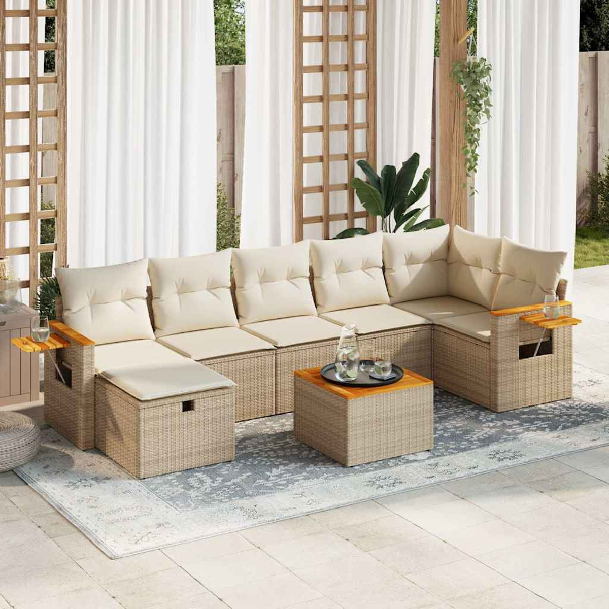Divano componibile da esterno con cuscini beige. Include un tavolino con bevande e un tappeto fantasia sul patio.